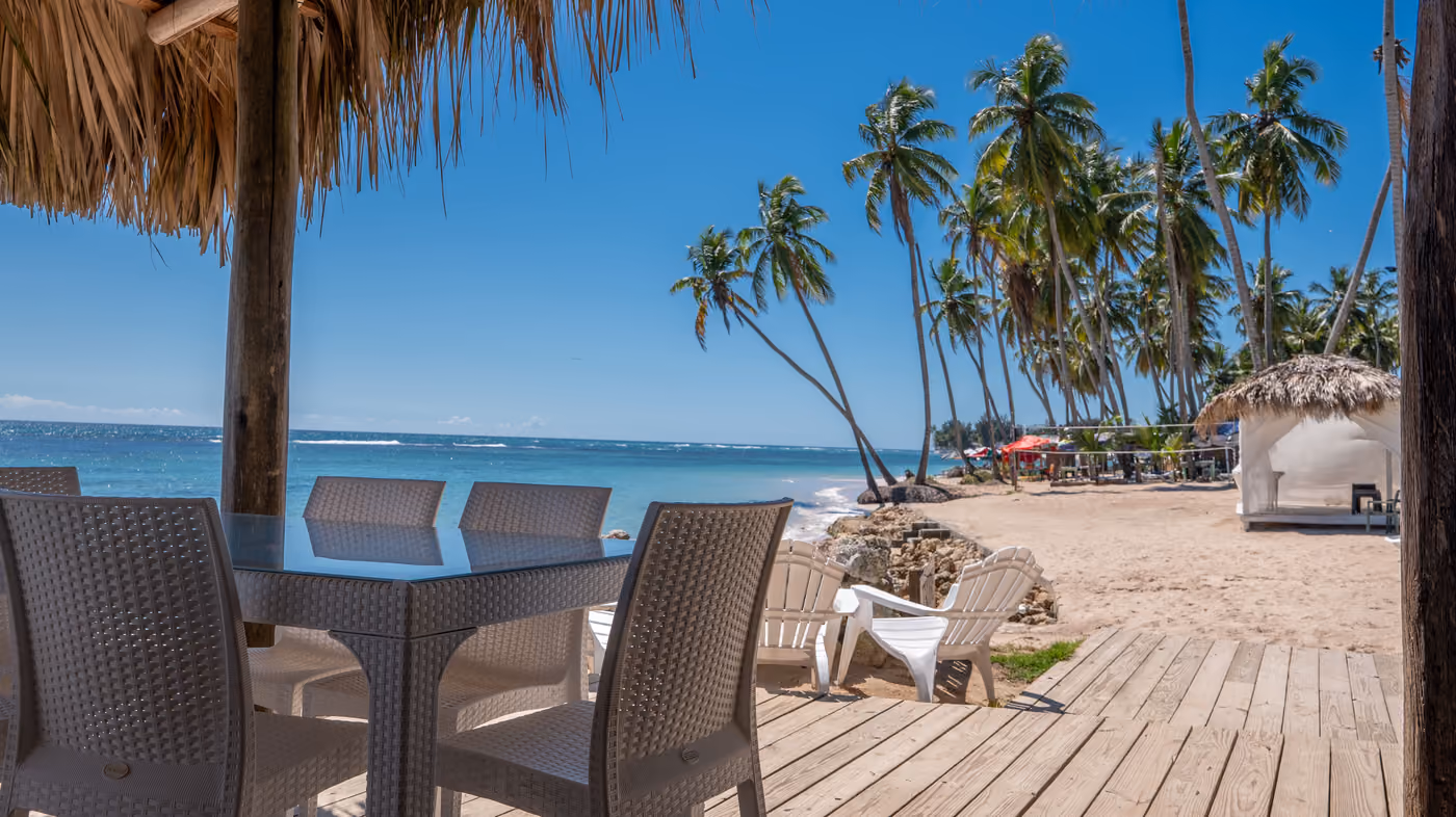 Terraza de madera con mesas frente a la playa