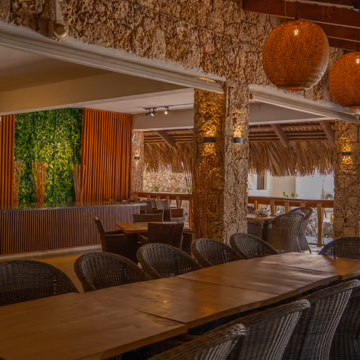 Restaurante de Casa Cora con lámparas de mimbre y muros de piedra