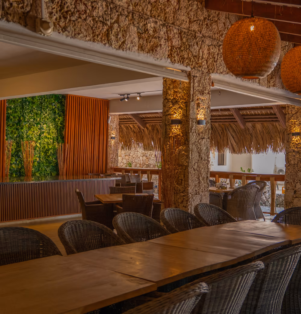 Restaurante de Casa Cora con lámparas de mimbre y muros de piedra